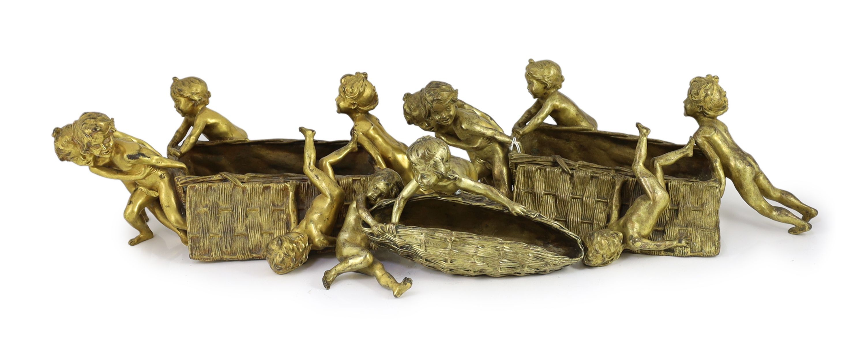 Raoul Francois Larche (French, 1860 - 1912). A set of three ormolu groups of children pushing and pulling large wicker baskets, largest length 45cm height 17cn smaller length 27cm height 16cm